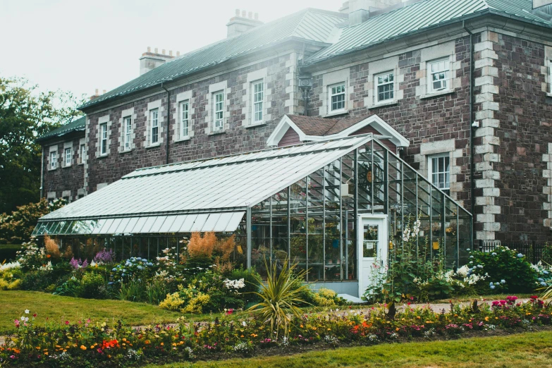 an old building with a lot of flowers in front of it