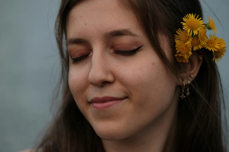 a beautiful young woman wearing a yellow flower in her hair