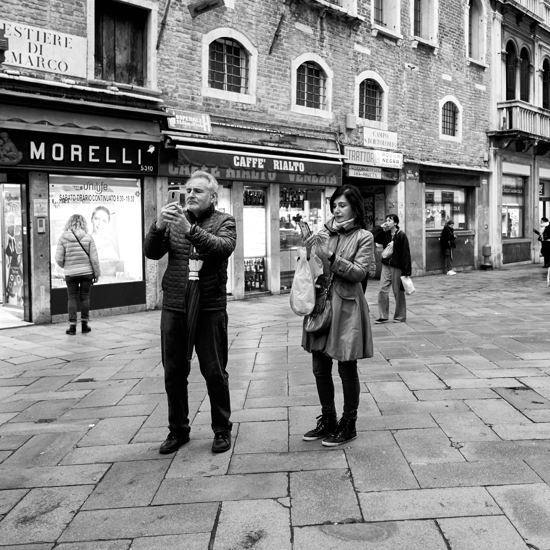 two young adults standing in the street with their arms folded