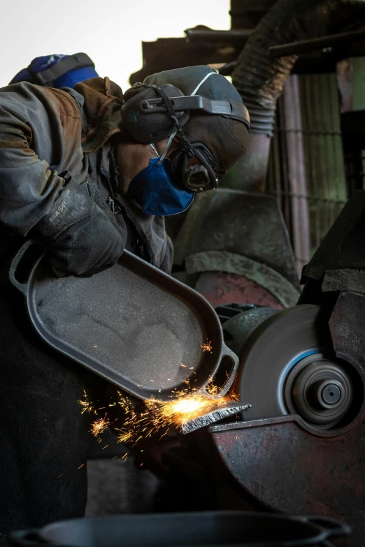 welder in welding gear works on a piece of metal