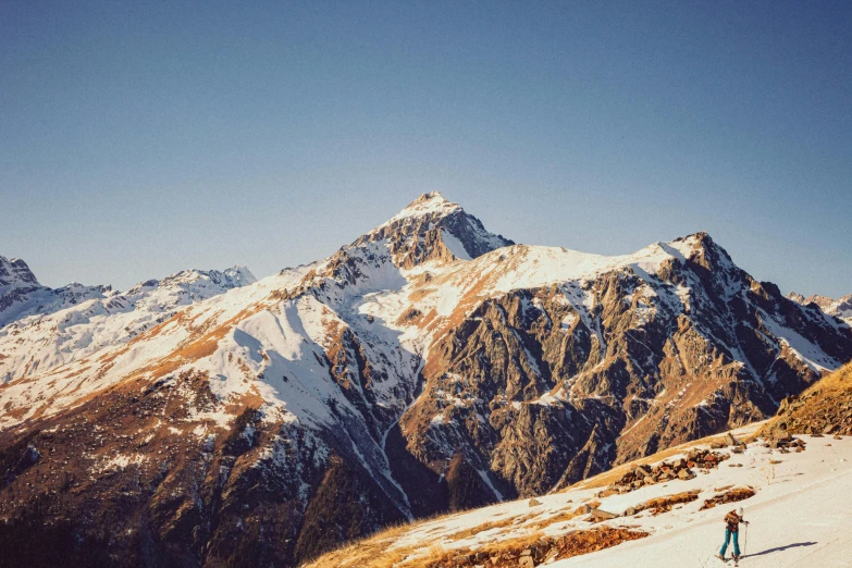 two people on skis are at the top of a snowy mountain