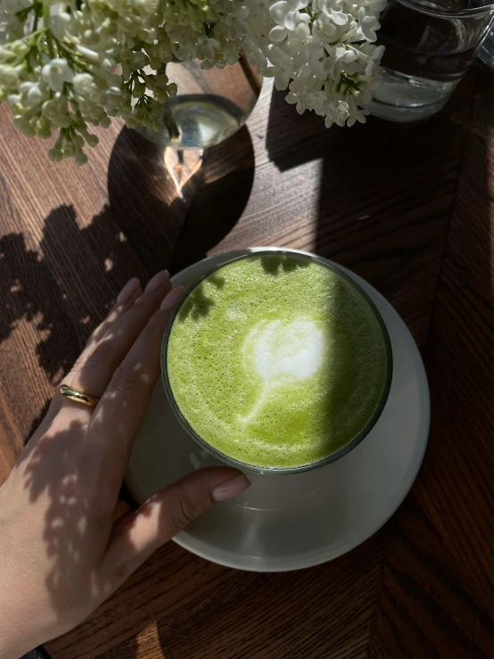 a green beverage sits in a bowl on a table