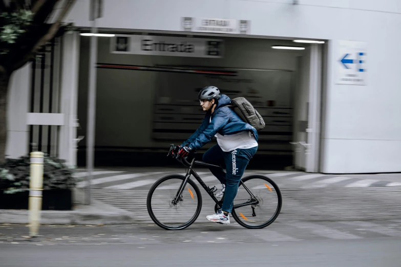 a man riding a bicycle past a building