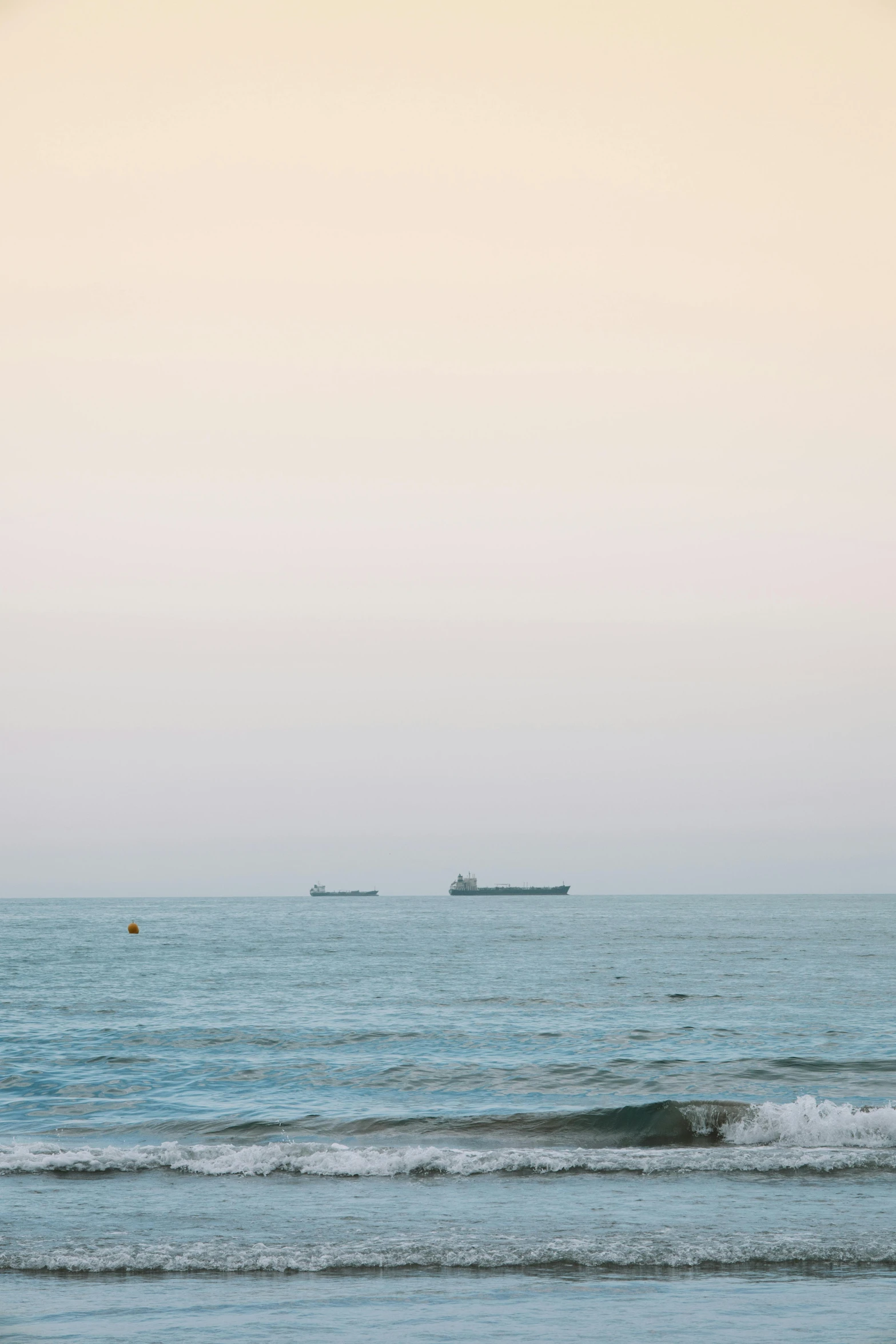 the ocean has a small boat sailing near shore