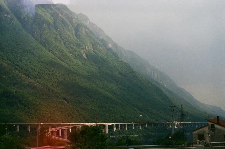 the road next to the big mountain with a bridge going over it