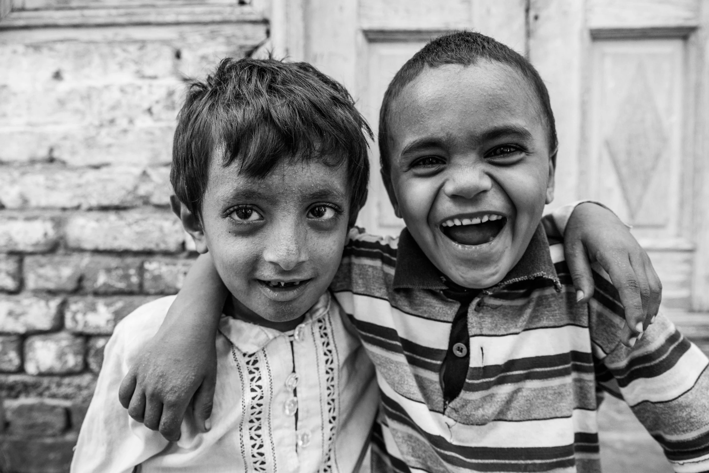 two s in striped shirts are posing for the camera