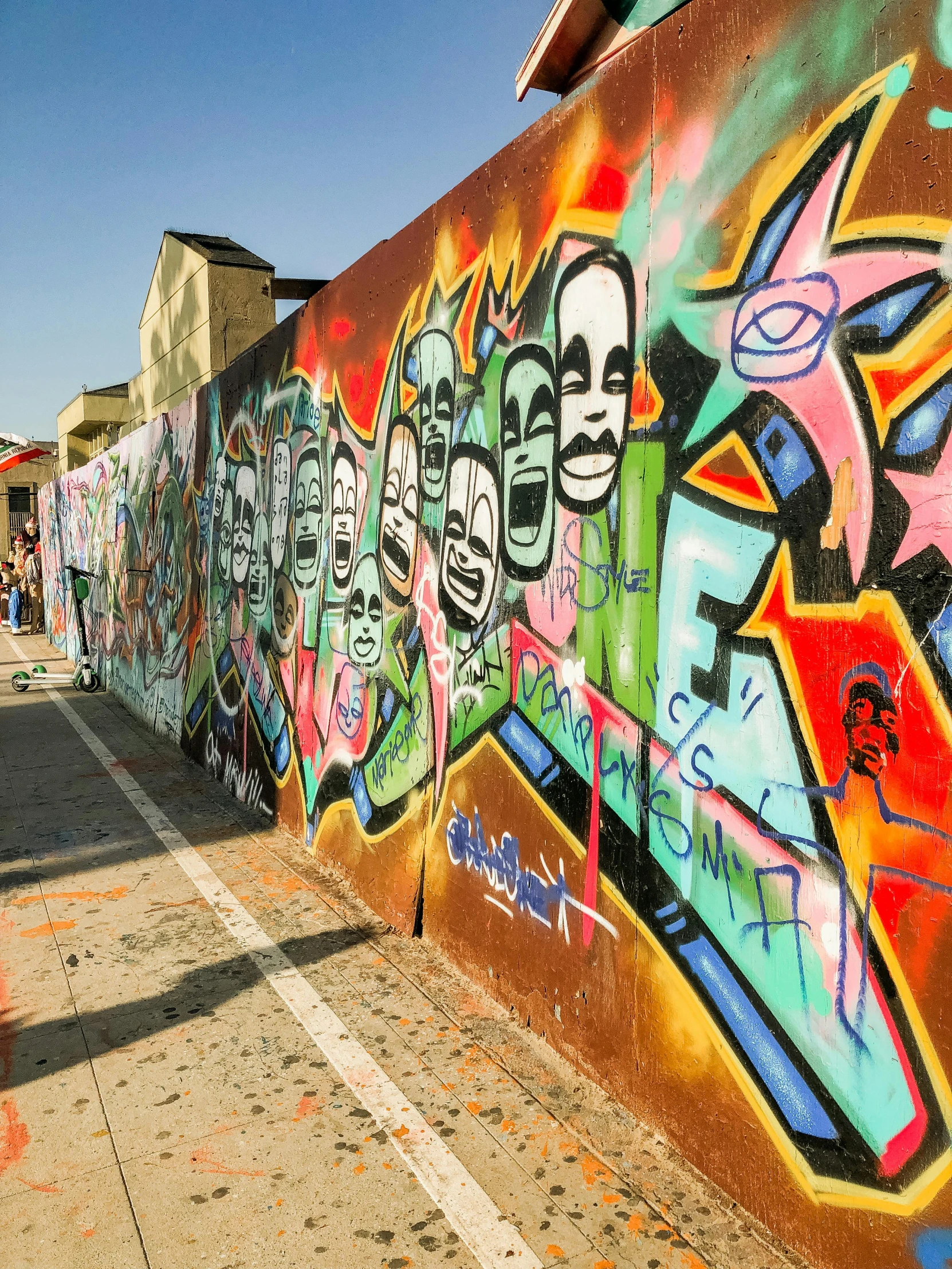 a man in a white shirt is looking at graffiti on a wall