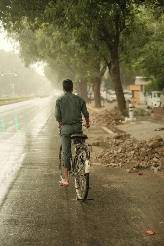 a man riding his bike on a street next to trees