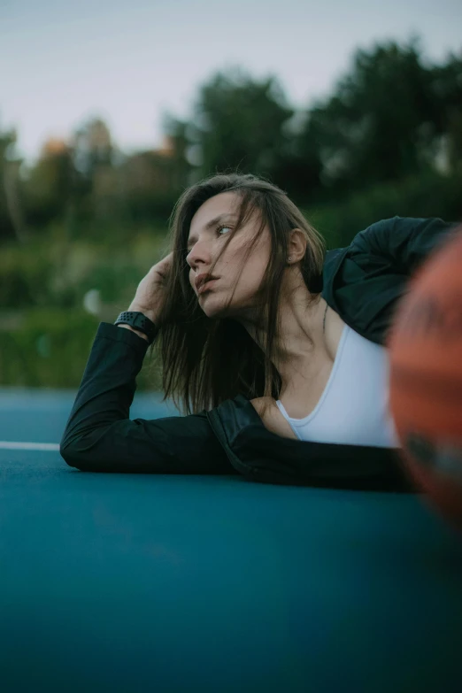 a woman with glasses sitting on the side of a tennis court