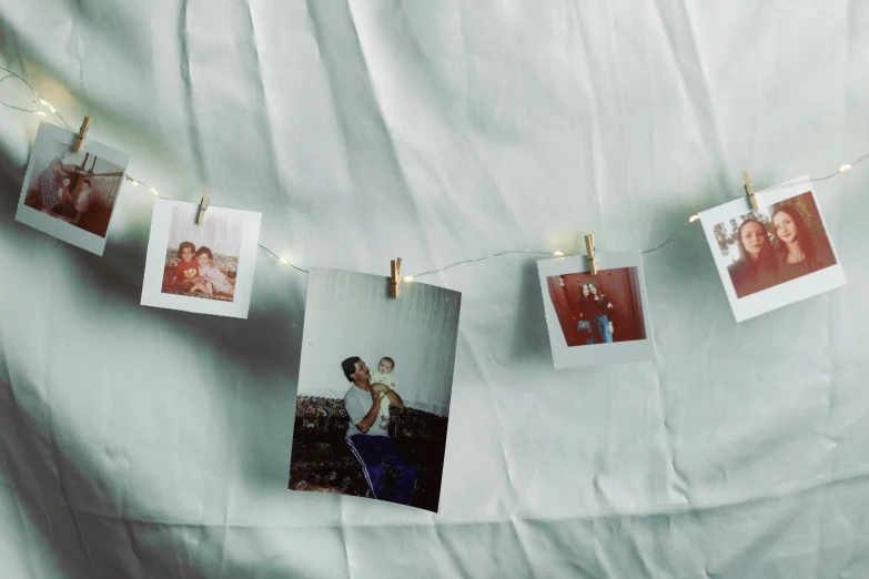 there are polaroid pictures hanging from the clothes line