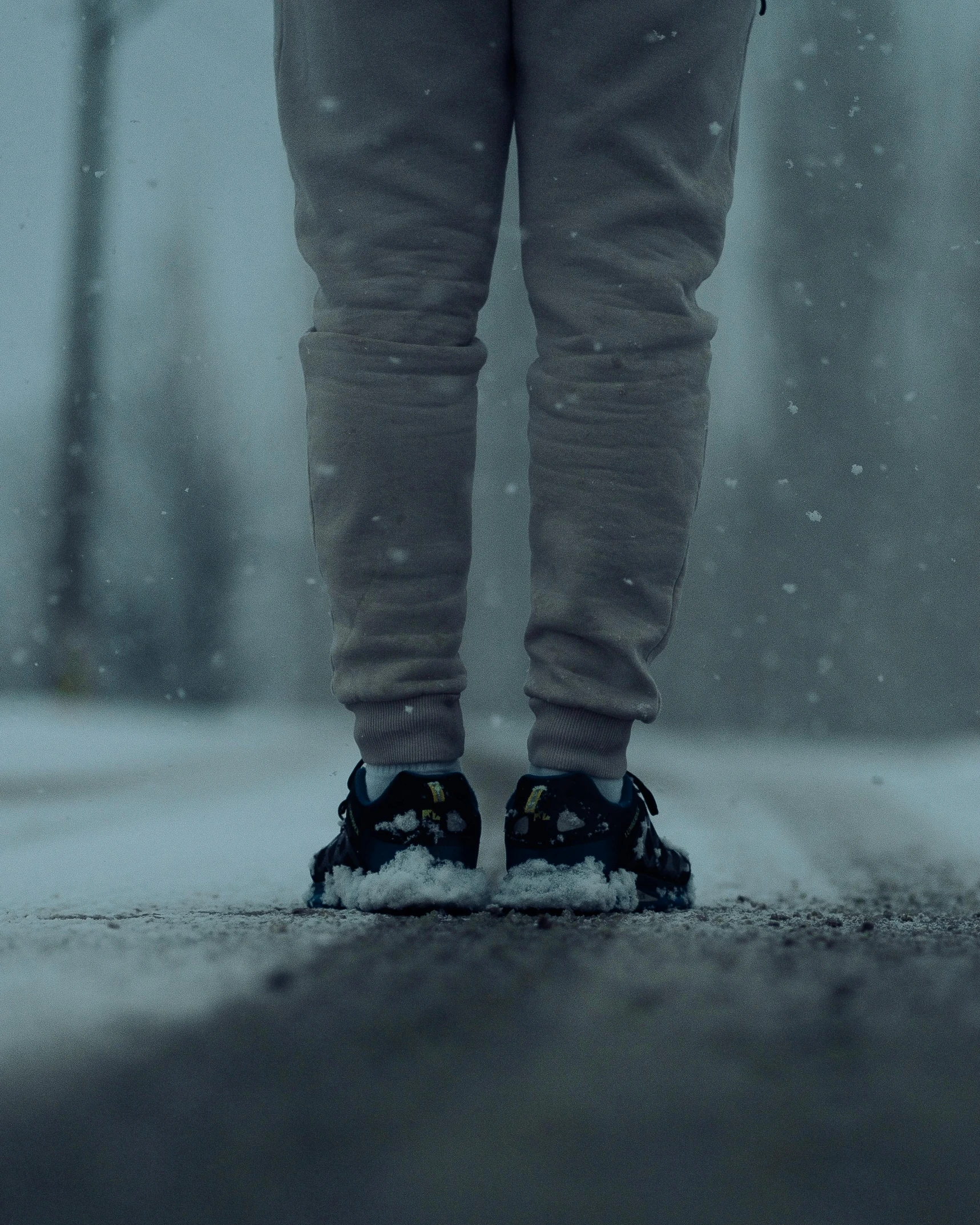 the person in a pair of black shoes is standing on a rainy day