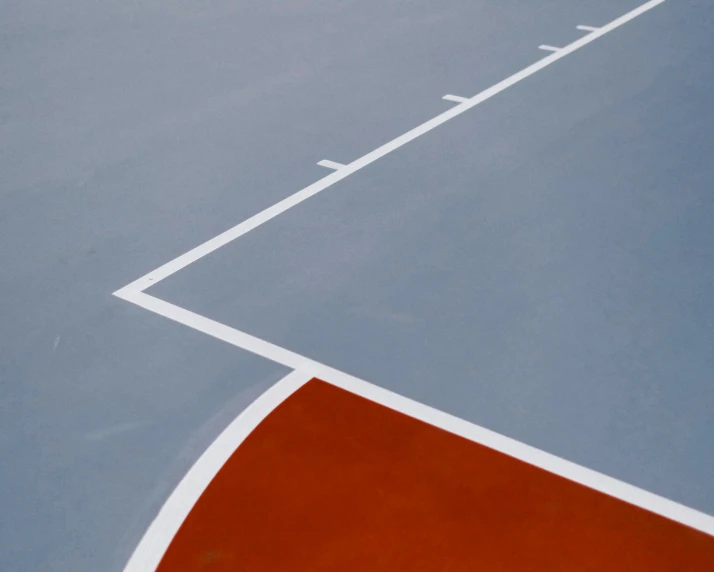 tennis court with orange and white line painted across the edges