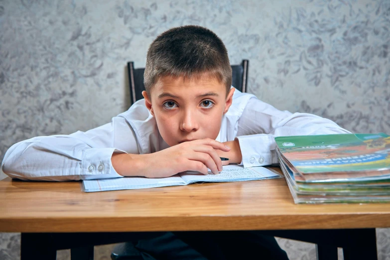 boy with book laying in his lap in the table