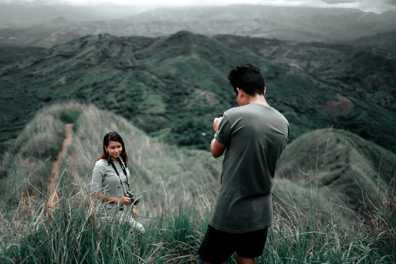 couple in grass looking at a view on mountains