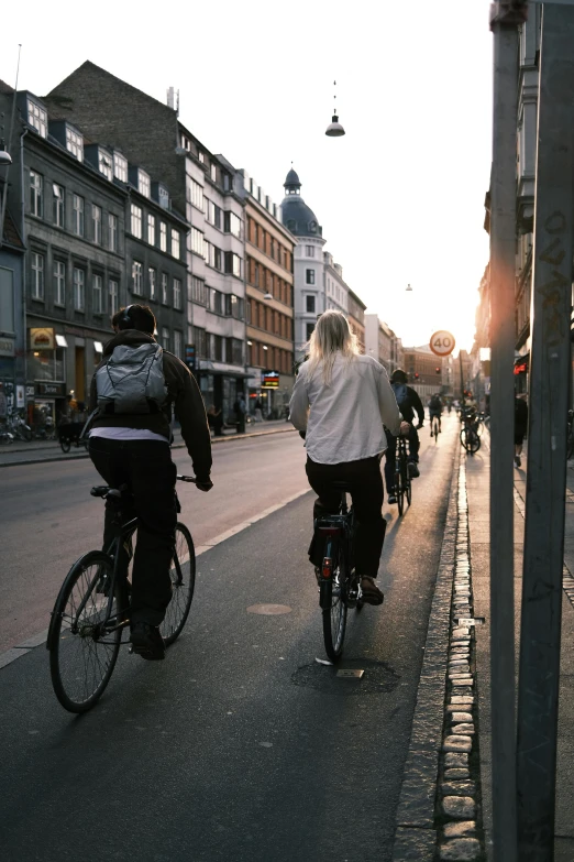 a couple of people riding bikes down the street