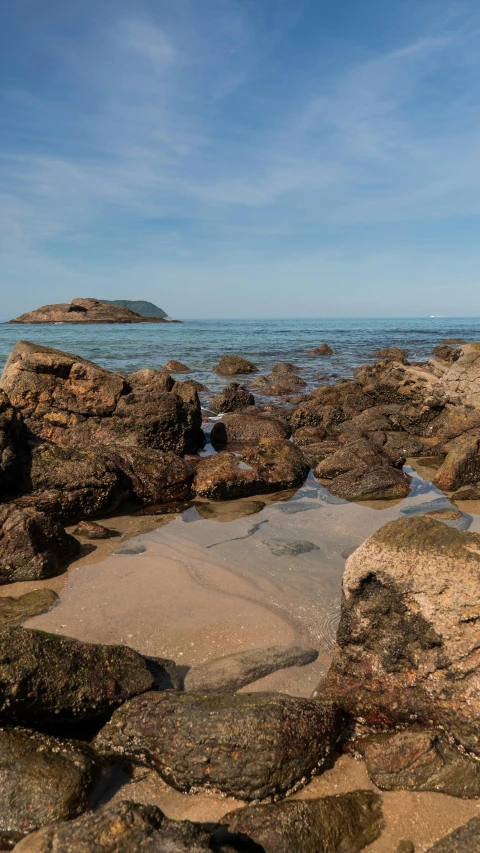 there is water running over some rocks at the beach