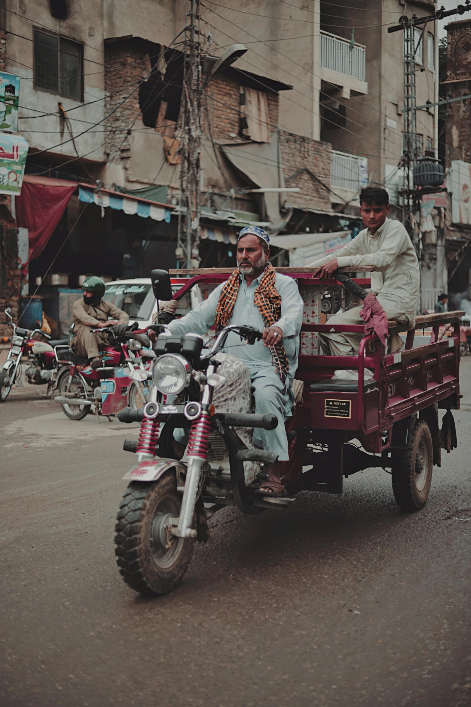 a man driving a motorcycle while sitting in the back of a vehicle