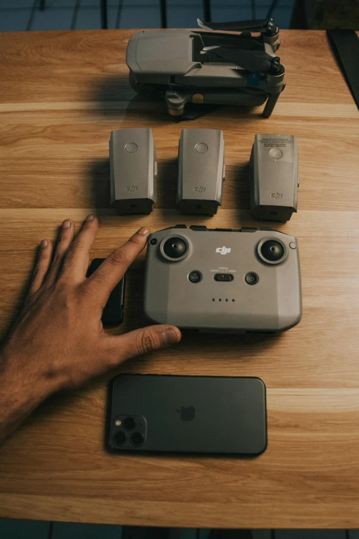 a person holding their smartphone and various cell phone components on a table