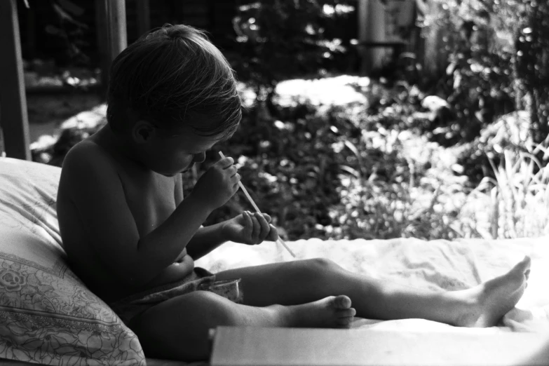 a little  with a book on a bed