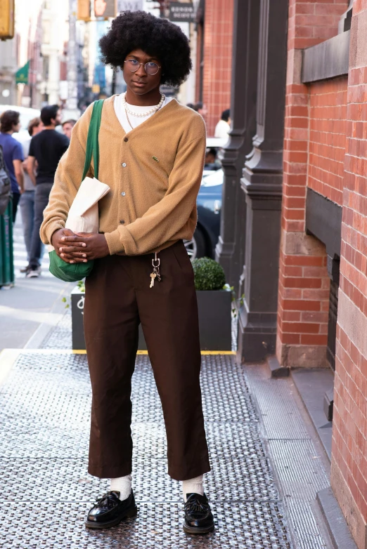 a person with an afro standing on a street