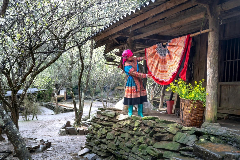 a woman standing near a wood structure with a large piece of cloth on it