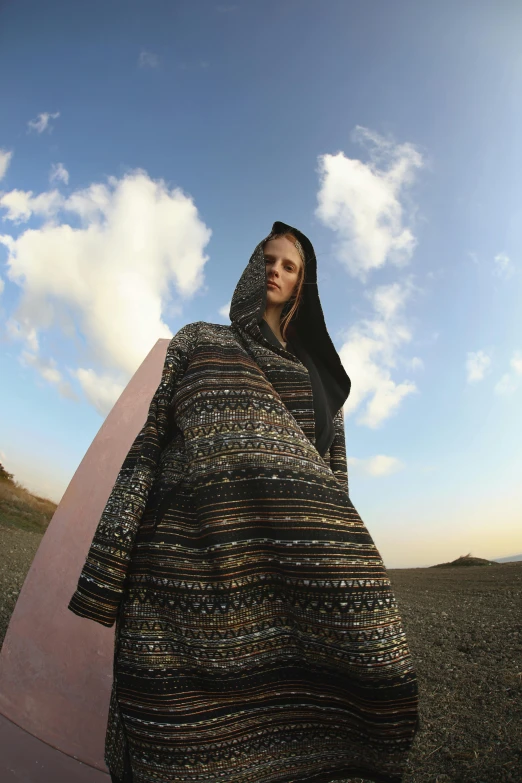 a woman is dressed in black and brown sweater