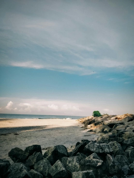 beach scene with rocks and a bench near the shore