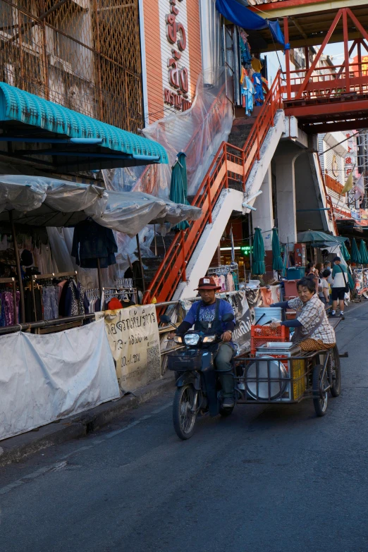 three men are selling goods on the back of a motorcycle