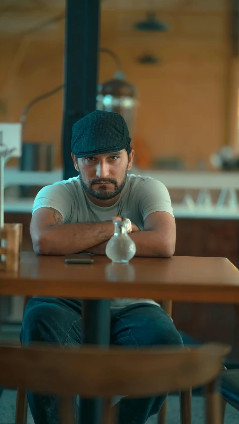 a man with his hand on his chest sitting at the table