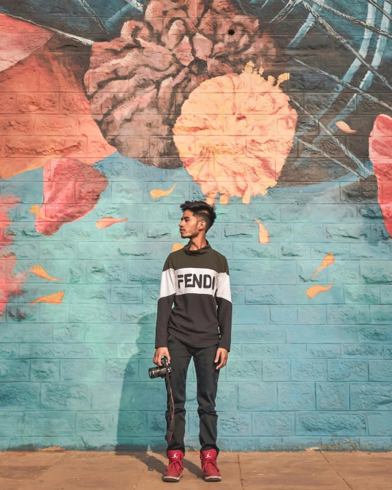 a person standing in front of a painted wall