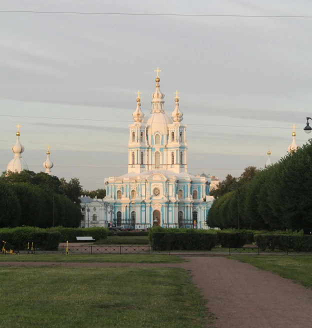 a large building sitting next to a lush green field