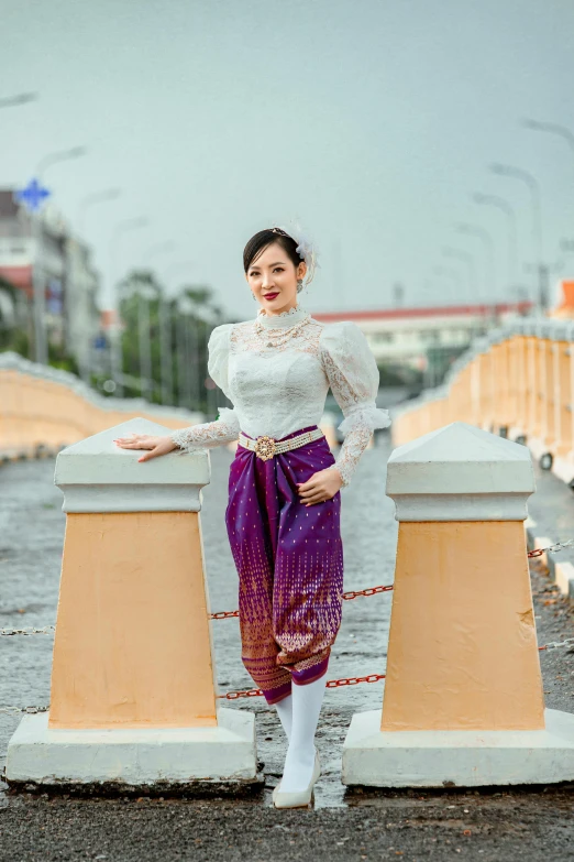 woman with colorful dress posing on yellow pillars