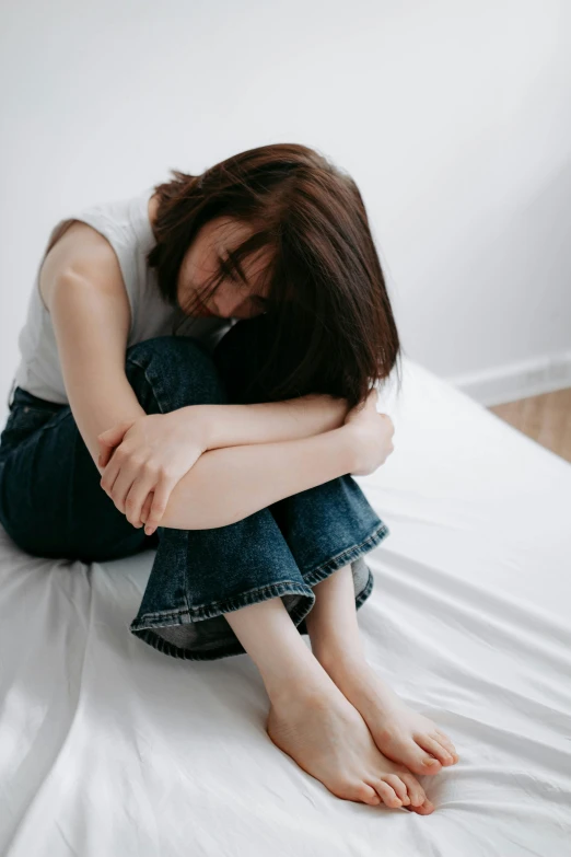 a woman is sitting on her stomach on a bed