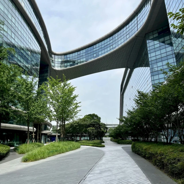 a sidewalk in front of two buildings with curved windows