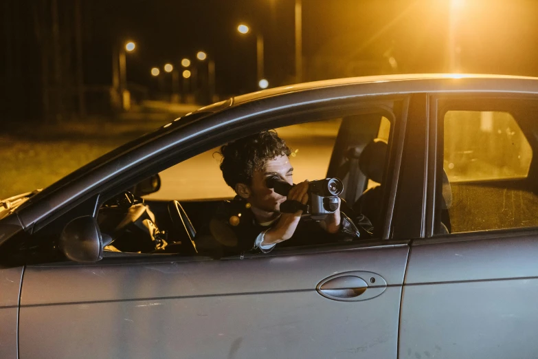 a man looking out the window of a car with a camera