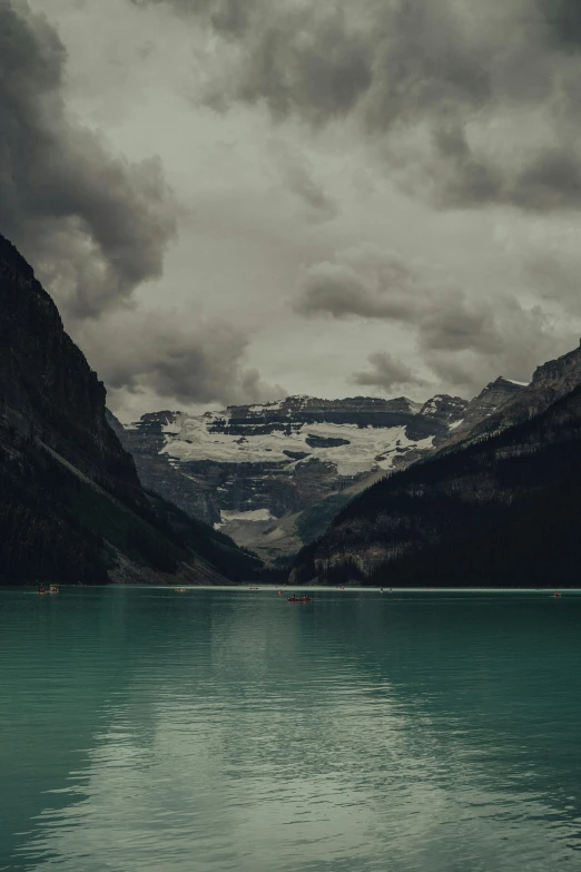 the water on a rainy day with mountains in the background