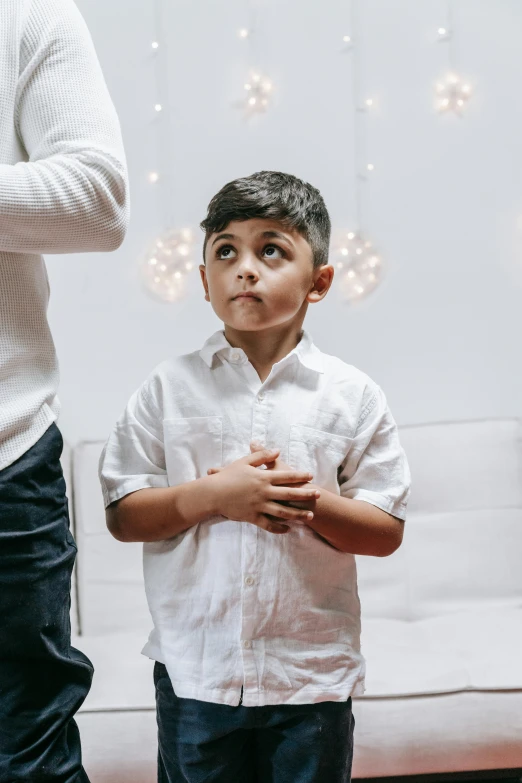 a boy is standing in front of a wall and looking up