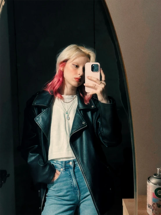 a young woman with pink hair holding a cell phone