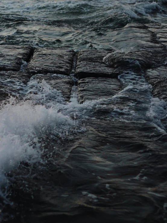 some small waves near rocks and water