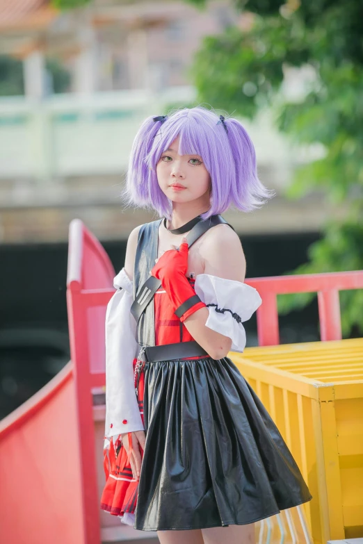 a girl in a purple wig is standing by some bright yellow barriers