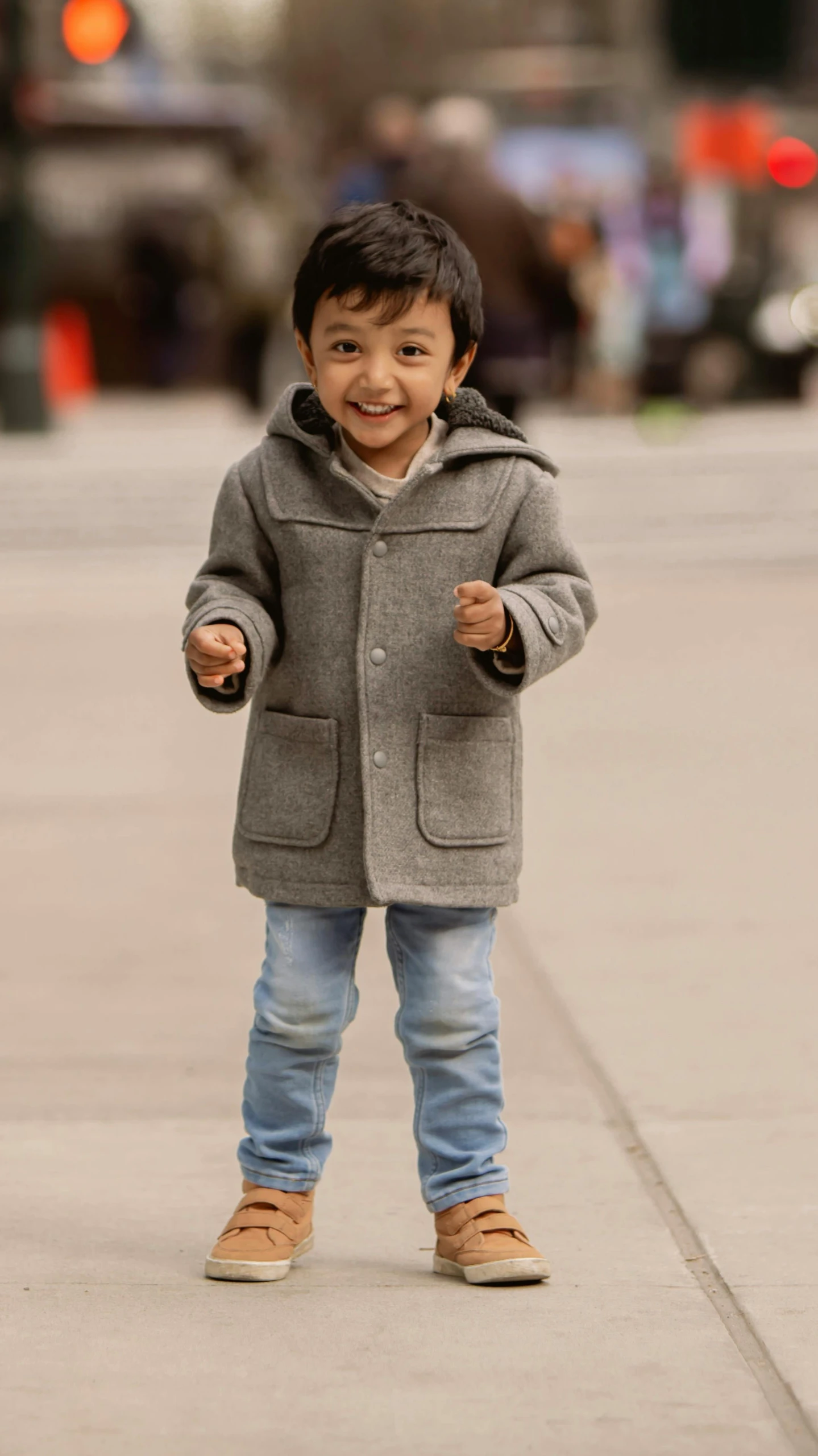 a little boy with his hand in the air and his thumb raised