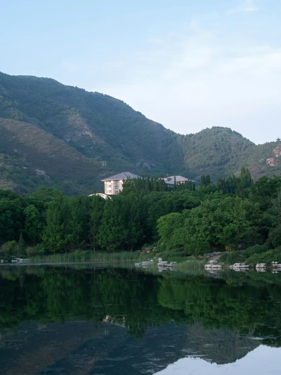 water and hills behind a house with a mountain