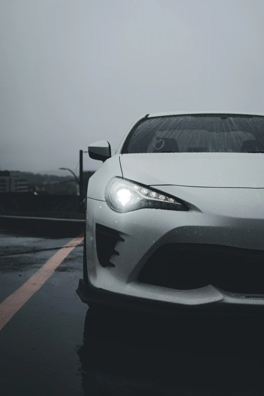 the front of a white toyota sports car in a parking lot