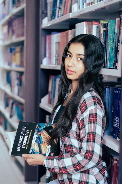 a woman is holding a book while standing in a liry