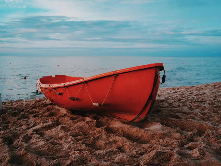 a row boat is on the sand on a beach