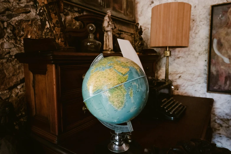 a globe is sitting on a table in front of an old piano