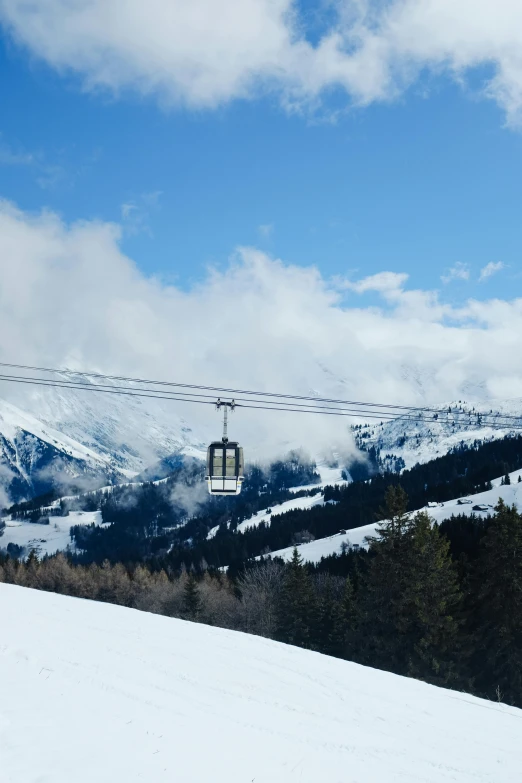 an empty chairlift is above the snowy mountains