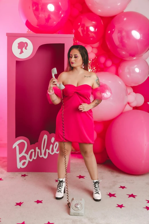 woman in red dress holding an object in front of balloons