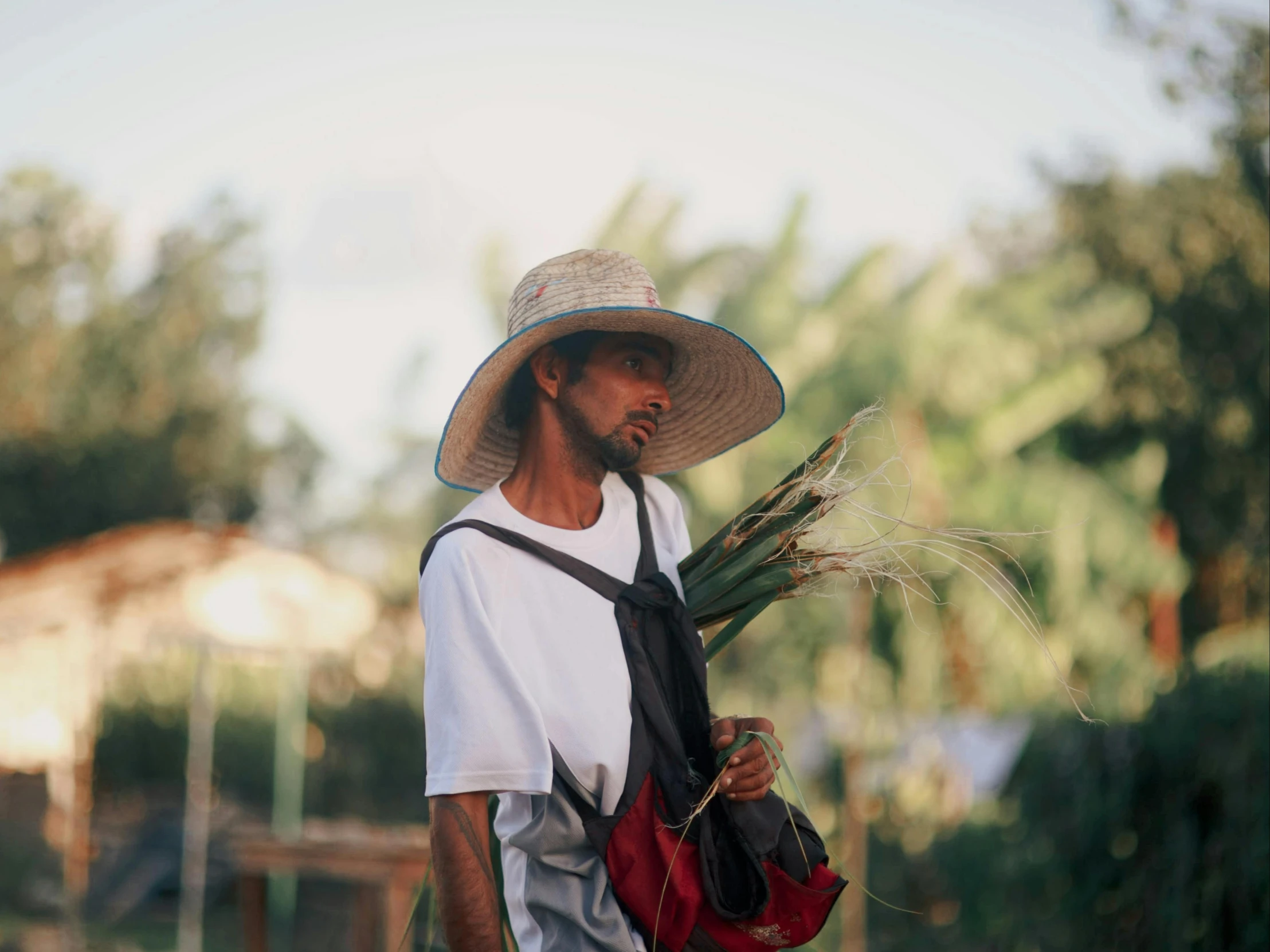 a man in hat and backpack with green grass