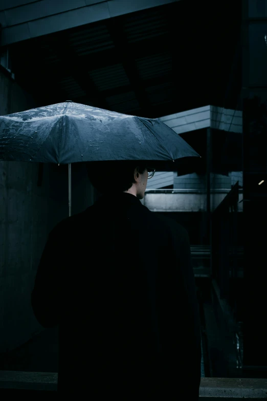 a man with a black shirt holding an umbrella